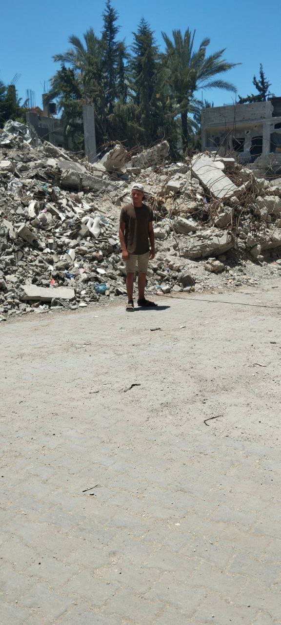 Young man standing among rubble in Gaza, Palestine